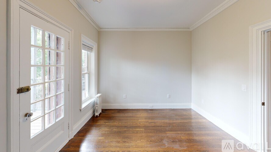 A room with a wooden floor and white walls.