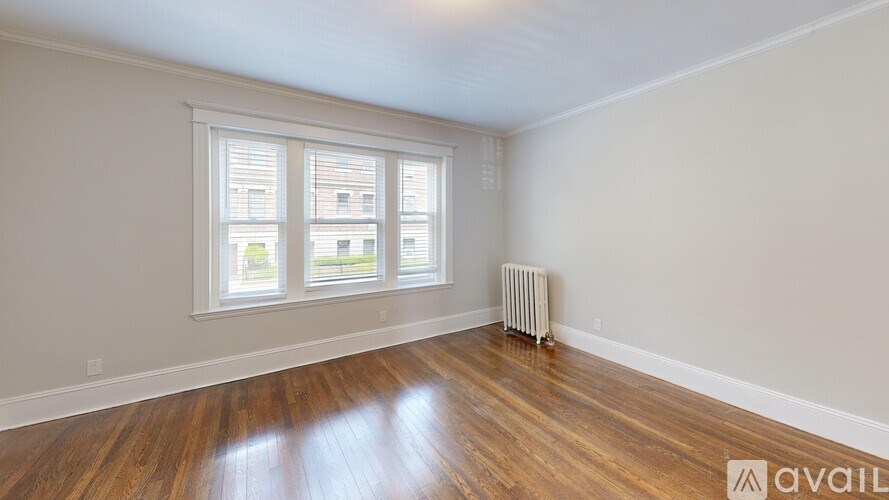 A room with wooden floors and a window with blinds.