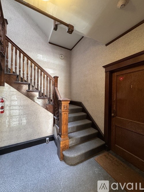 A staircase with a wooden banister and a brown door.