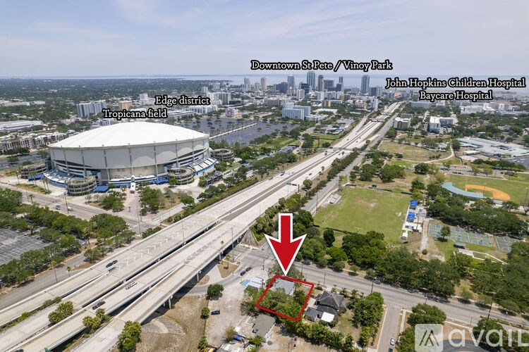 An aerial view of a city with a red arrow pointing to a specific location.