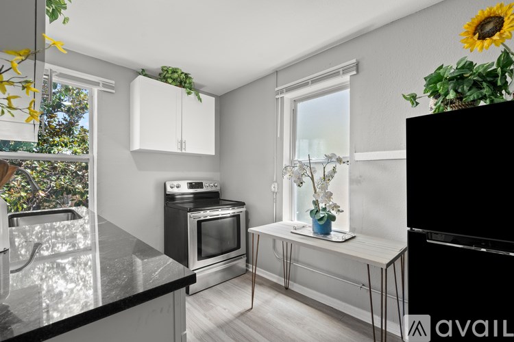 A kitchen with a black countertop and a stainless steel oven.