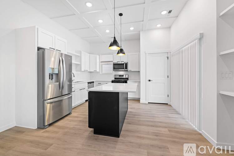 A modern kitchen with a black island in the middle.