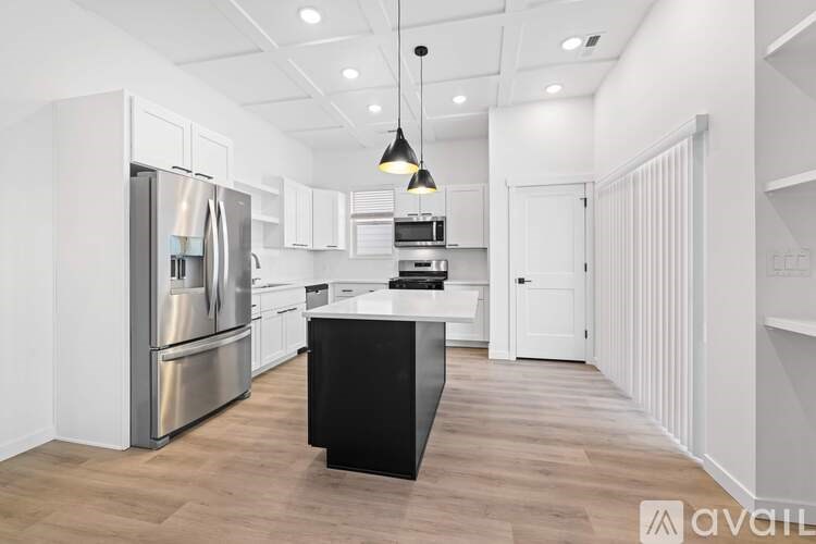 A modern kitchen with a black island in the middle.