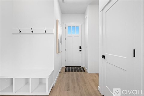 A room with wooden flooring and a window with blinds.