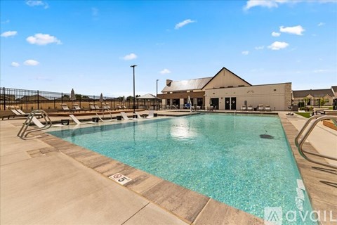 A large outdoor swimming pool with lane markers and a building in the background.