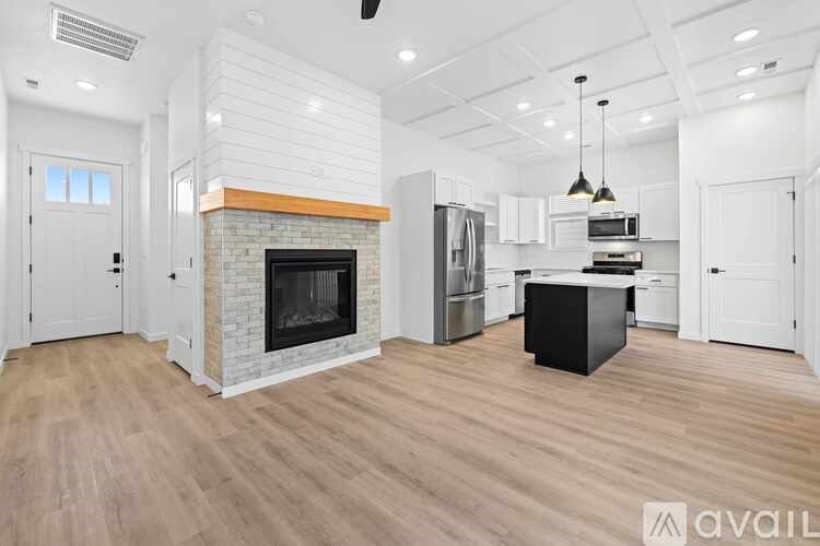 A modern kitchen with a fireplace and wooden floors.
