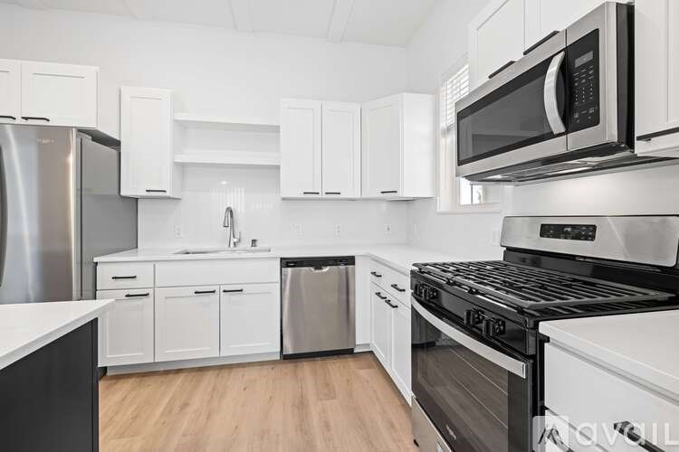 A kitchen with white cabinets and appliances.