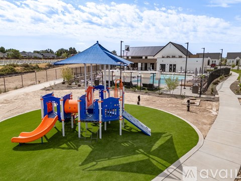A playground with a blue canopy and orange and blue slides.