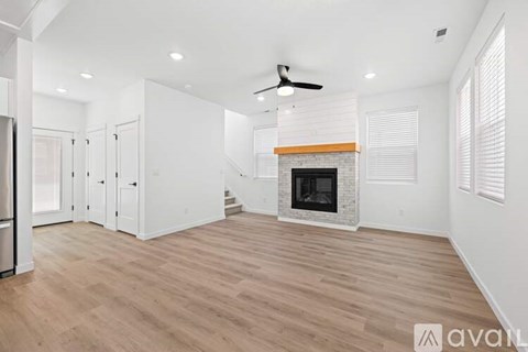 A spacious living room with a fireplace and wood flooring.