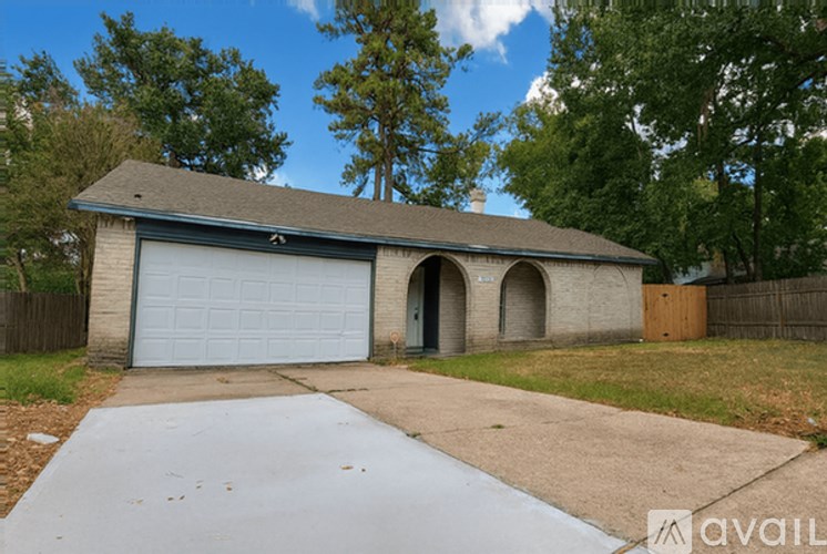 A detached house with a grey garage door and a driveway.