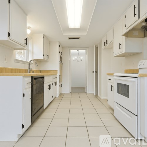 A kitchen with white appliances and cabinets.