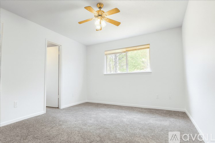 A room with a ceiling fan and a window.