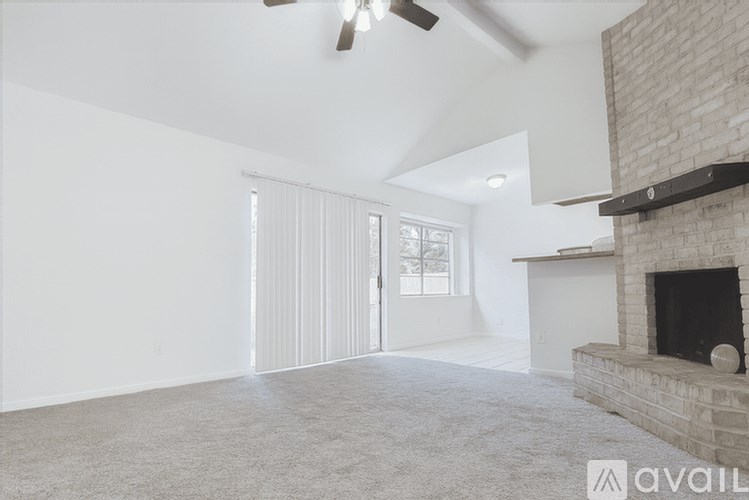 A living room with a fireplace and a ceiling fan.