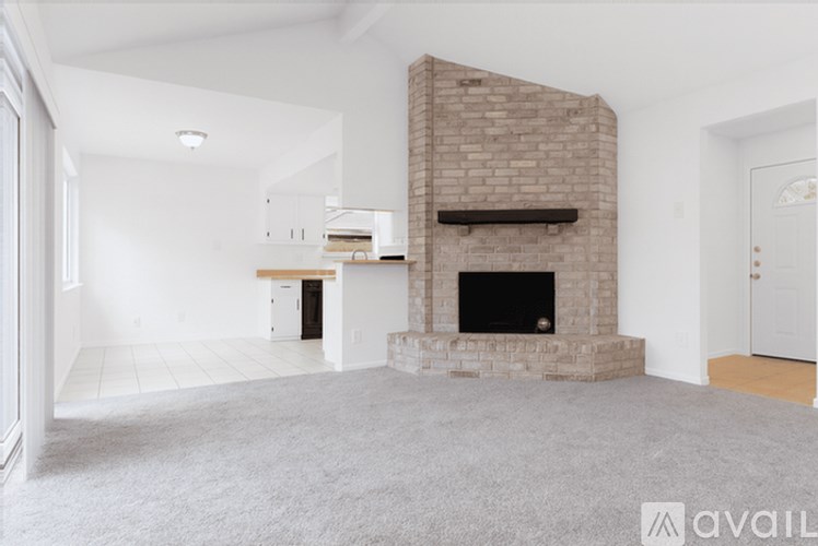 A living room with a fireplace and a carpeted floor.