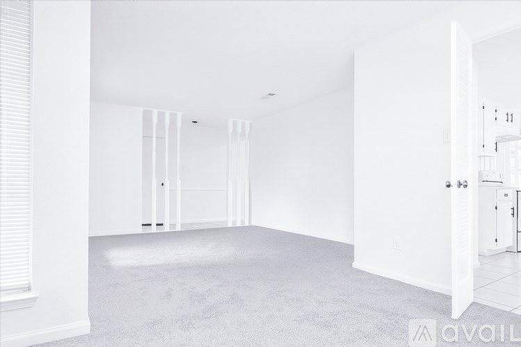 A spacious, empty room with white walls and carpeted floor.