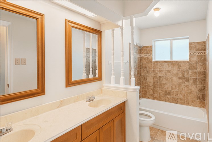 A bathroom with a tub, sink, mirror, and toilet.