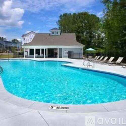 A pool with a house in the background.