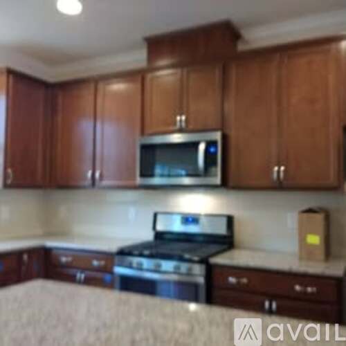 A kitchen with wooden cabinets and a microwave above the stove.