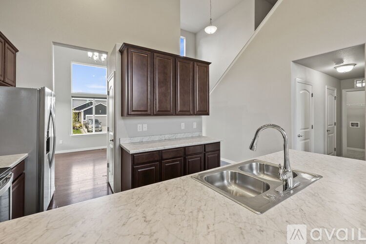 A kitchen with a marble countertop and a stainless steel sink.
