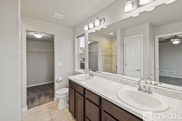 A bathroom with a toilet, sink, and mirror.