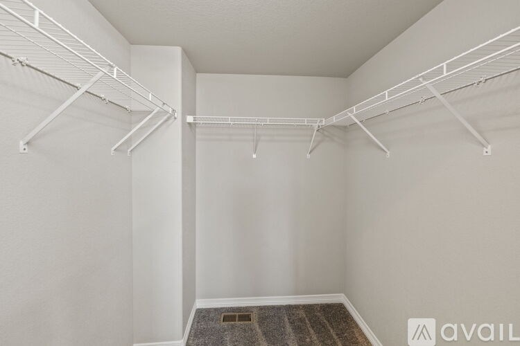 A white room with a carpeted floor and two white shelves.