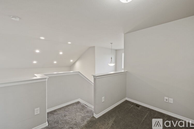 A room with a carpeted floor and a hanging light fixture.