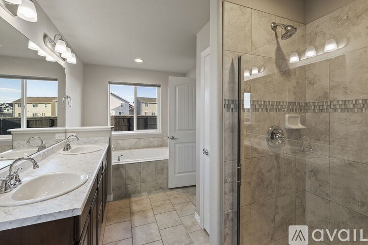 A bathroom with a walk-in shower and double sinks.