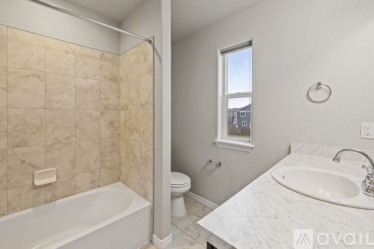 A bathroom with a tub, toilet, and sink.