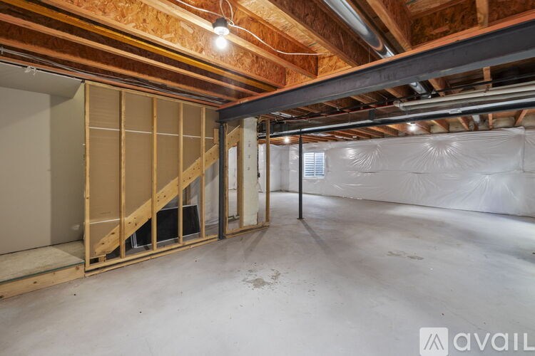A room under construction with wooden framing and a white floor.