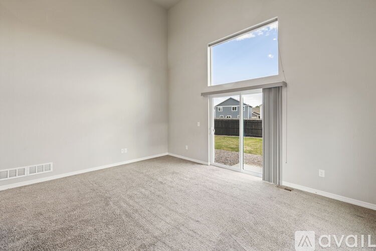 A room with a large window and a carpeted floor.