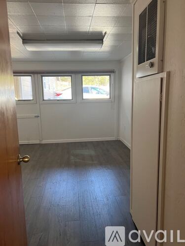 A room with a door, a window, and a wall-mounted air conditioner unit.