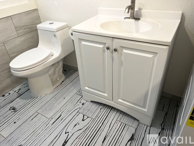 A white toilet and sink in a bathroom.