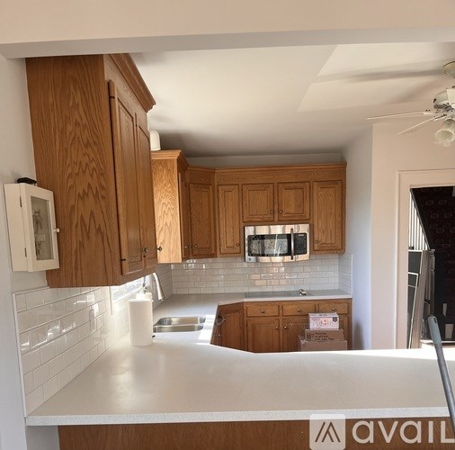 A kitchen with wooden cabinets and a white countertop.