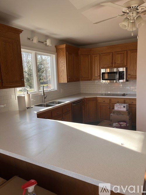 A kitchen with wooden cabinets and a white countertop is under construction.