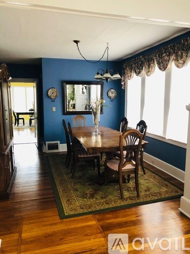 A dining room with a wooden table and chairs.