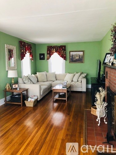 A living room with a white couch and a fireplace.