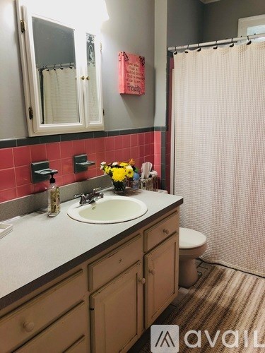 A bathroom with a white sink and a toilet.
