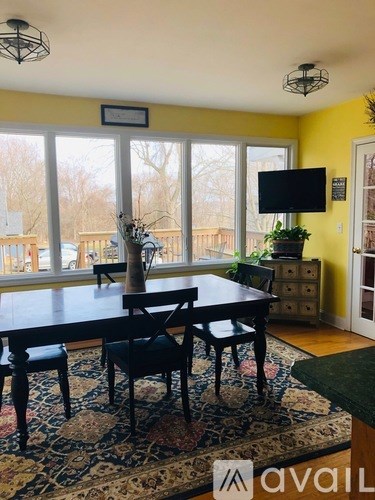 A dining room with a table and chairs.