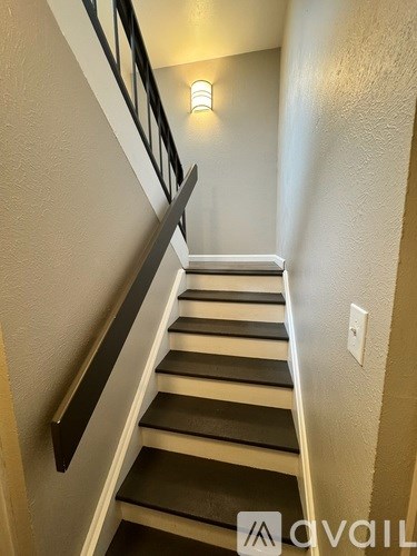 A staircase with a light on the wall.