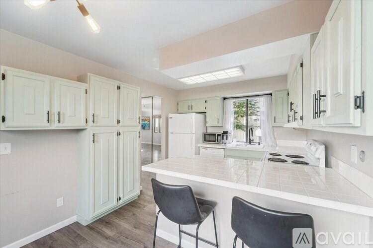 A long hallway with a wooden floor and white walls.