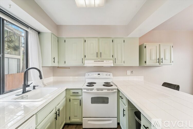 A room with wooden flooring and dark walls, with a white door on the right.