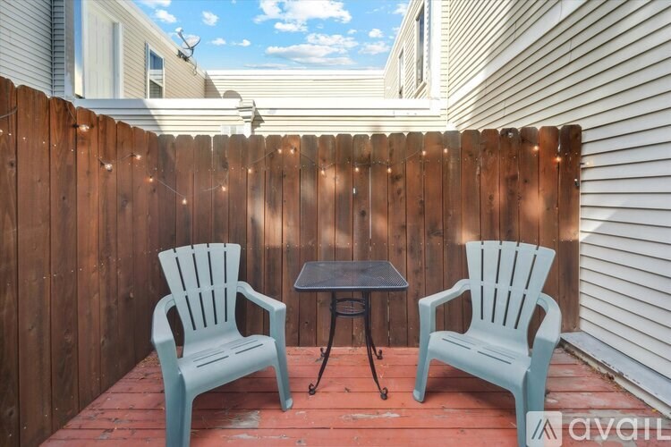 A spacious room with wooden flooring and a large window.