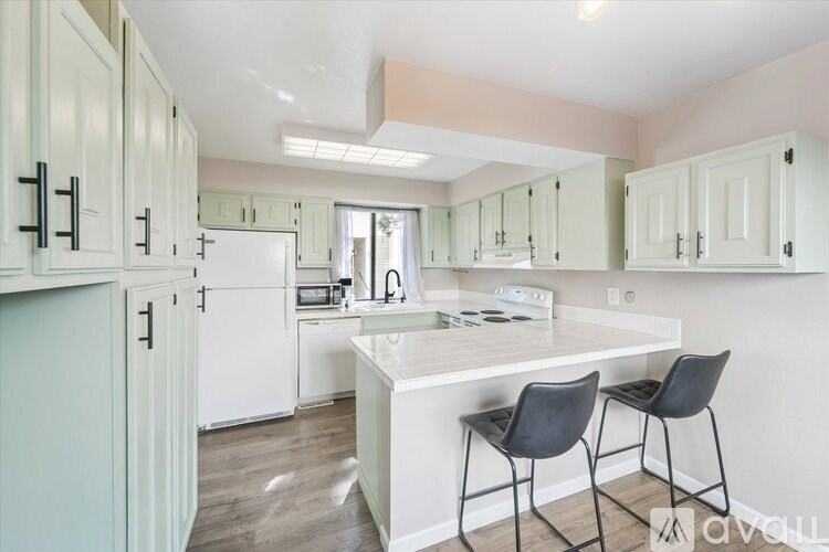 A kitchen with a table and chairs.