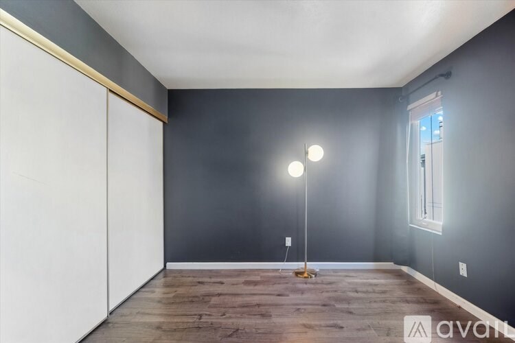 A spacious room with wooden floors and a glass wall.