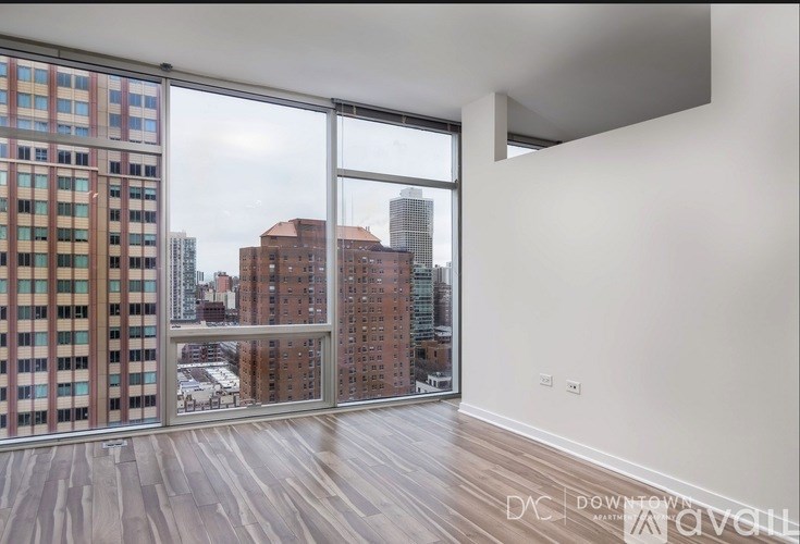 A bedroom with a large bed and a grey couch.
