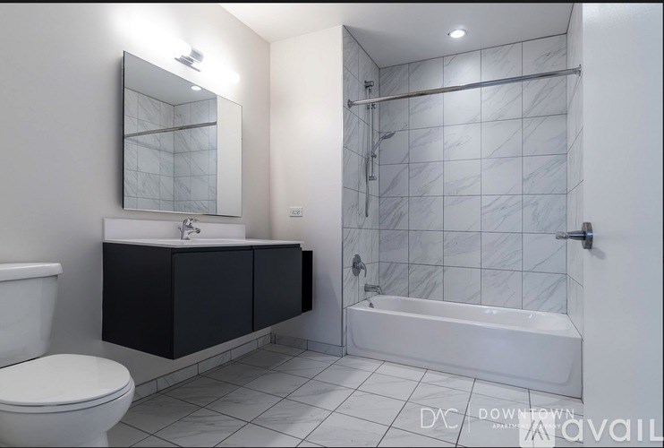 A kitchen with black appliances and wooden floors.