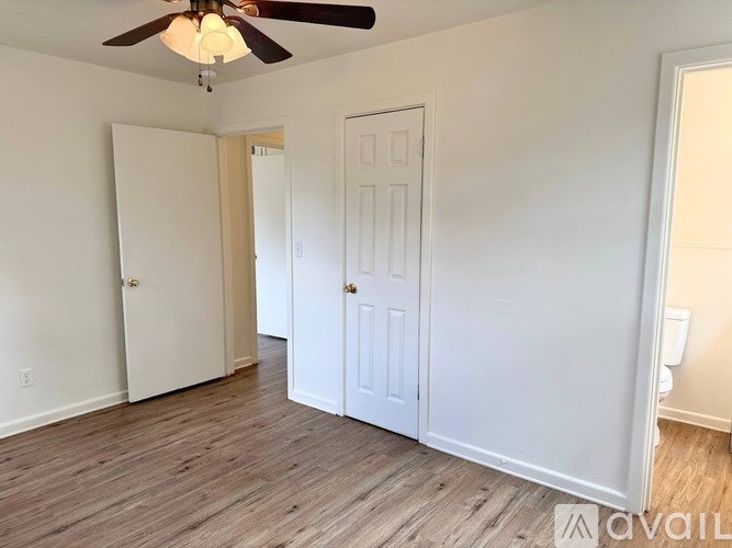 A room with a ceiling fan and two doors.