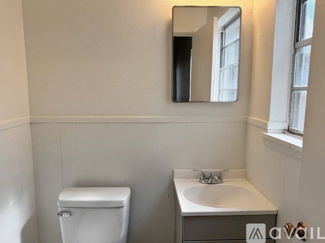 A white toilet sits next to a sink in a small bathroom.