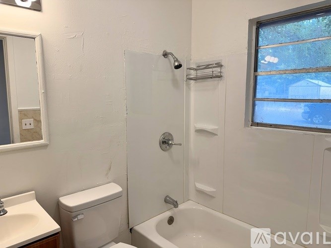 A white bathroom with a toilet, sink, and tub.