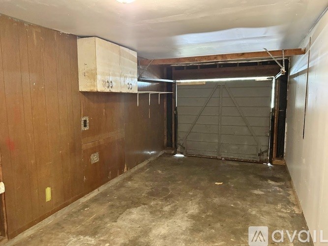 A large, empty warehouse with a metal gate and wooden walls.